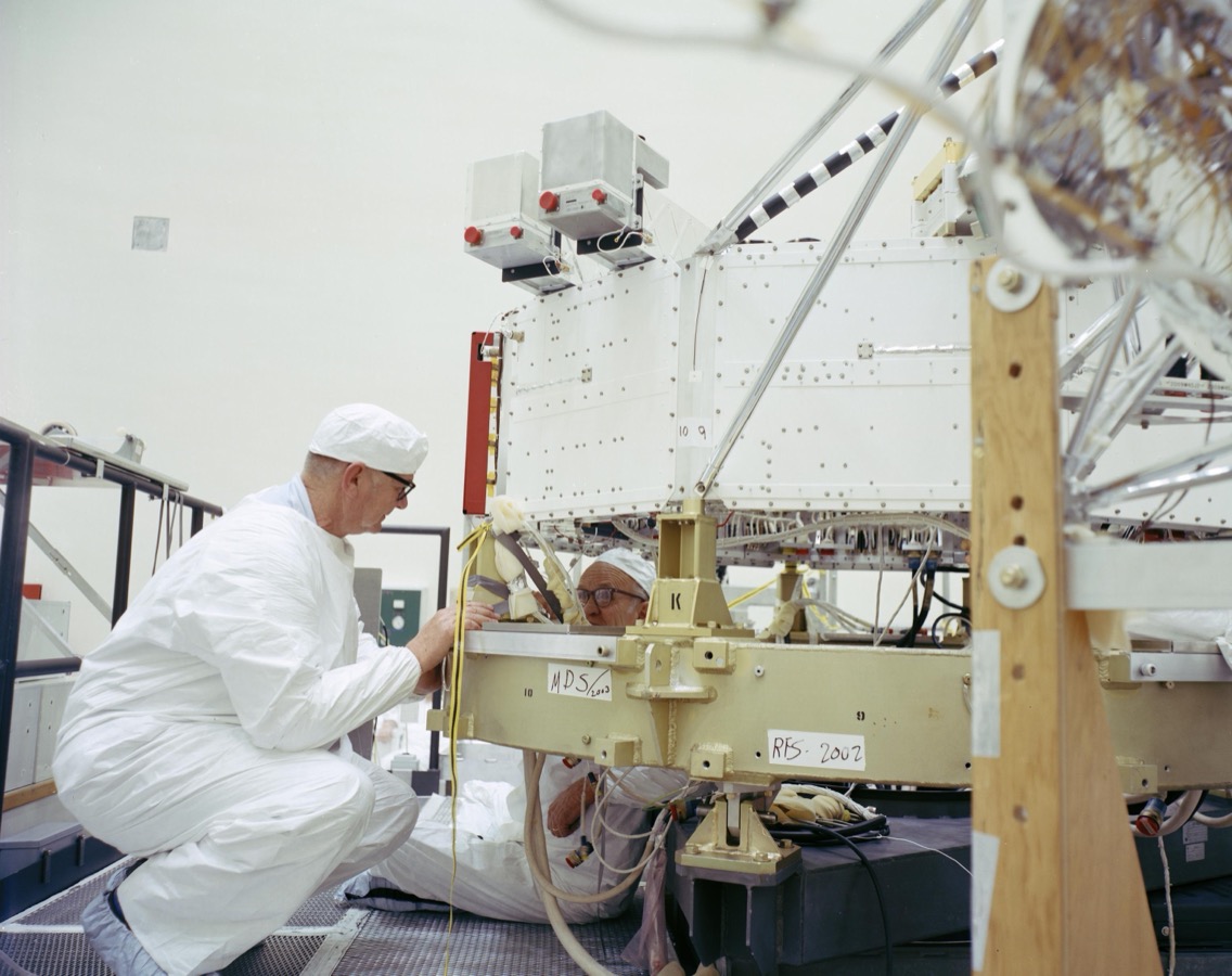 Engineers in a clean room assembling the ten-sided central body of the Voyager 2 spacecraft in 1977